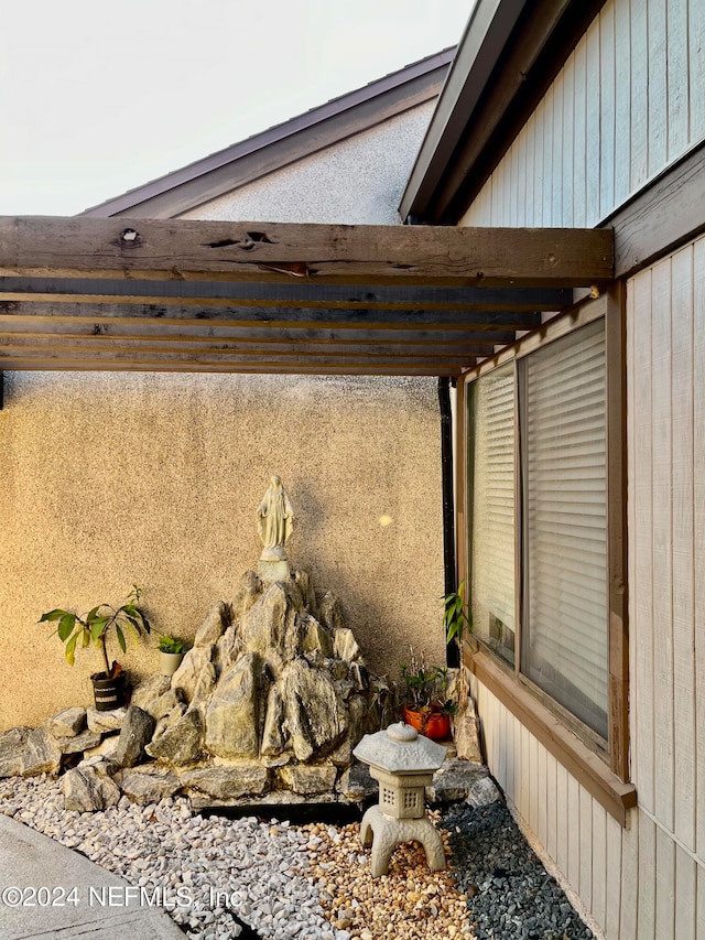 exterior details featuring wooden walls and beam ceiling