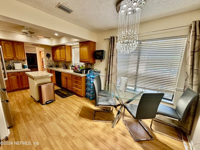 kitchen featuring light wood-type flooring, a textured ceiling, ceiling fan with notable chandelier, hanging light fixtures, and a kitchen island