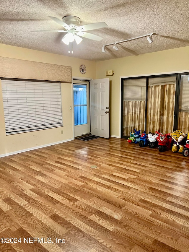 interior space featuring a textured ceiling, ceiling fan, and light hardwood / wood-style flooring