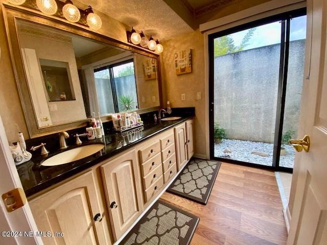 bathroom featuring wood-type flooring, a textured ceiling, plenty of natural light, and vanity