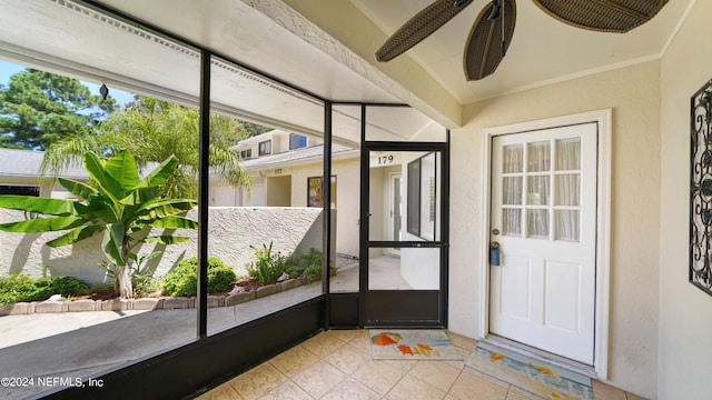 unfurnished sunroom with ceiling fan