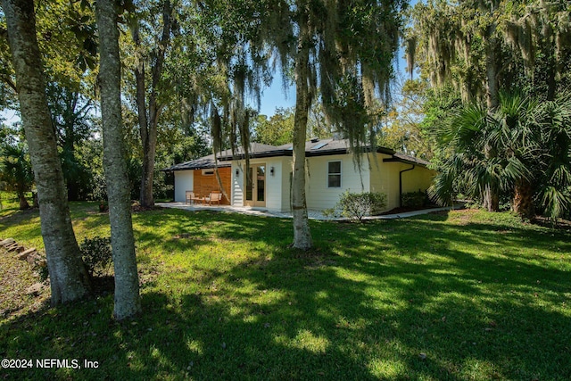 rear view of house featuring a lawn and a patio area