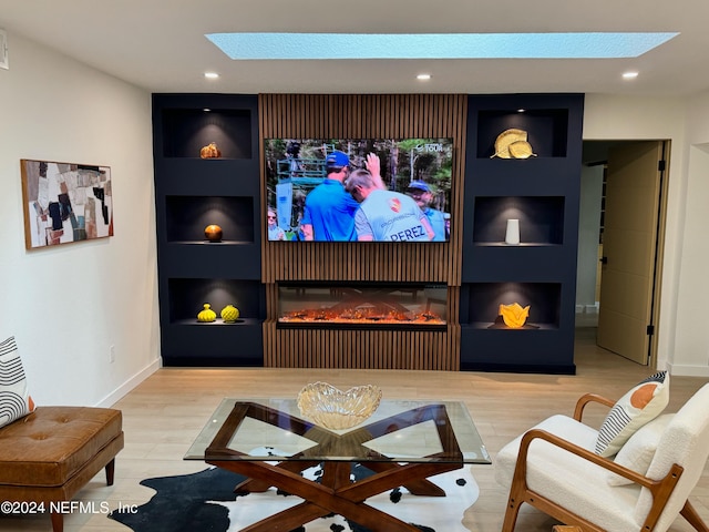 home theater room featuring built in features, wood-type flooring, and a skylight