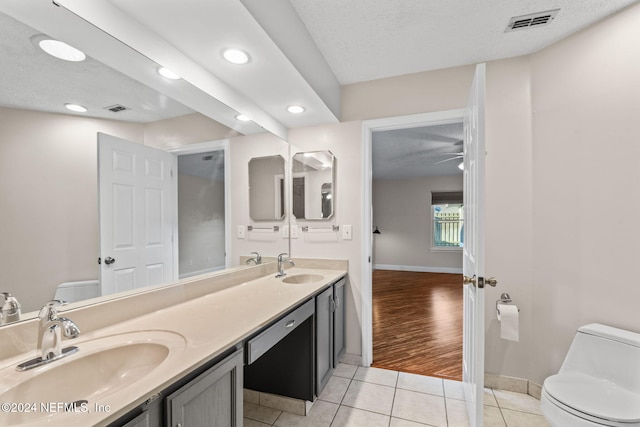 bathroom featuring vanity, a textured ceiling, toilet, and tile patterned flooring