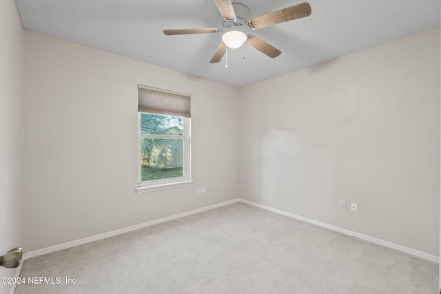 unfurnished room with ceiling fan, a textured ceiling, and light colored carpet