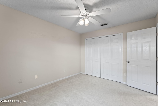 unfurnished bedroom featuring a closet, light colored carpet, and ceiling fan