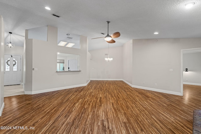 unfurnished living room featuring hardwood / wood-style floors, vaulted ceiling, a textured ceiling, and ceiling fan with notable chandelier