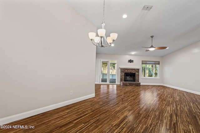 unfurnished living room with hardwood / wood-style floors, a brick fireplace, and ceiling fan with notable chandelier