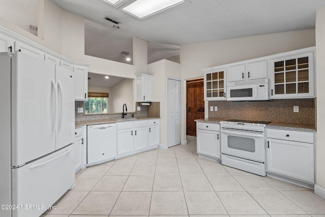 kitchen with white appliances, tasteful backsplash, sink, white cabinets, and light tile patterned floors