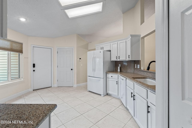 kitchen with white cabinets, sink, stone counters, and white appliances