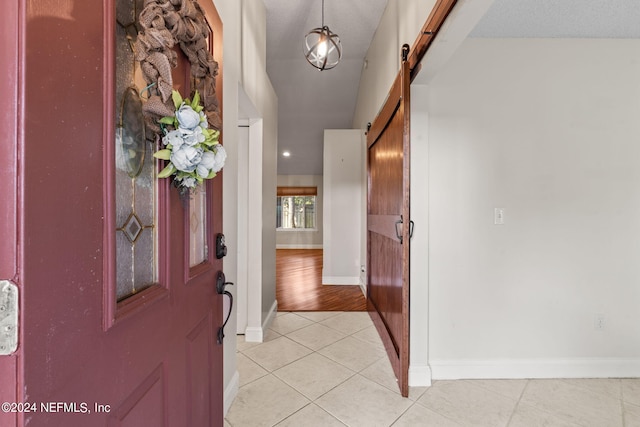 foyer with a textured ceiling, light hardwood / wood-style flooring, and a barn door