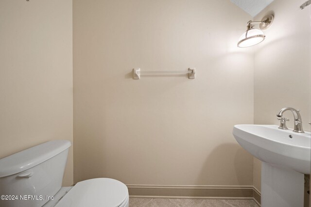 bathroom featuring sink, tile patterned floors, and toilet