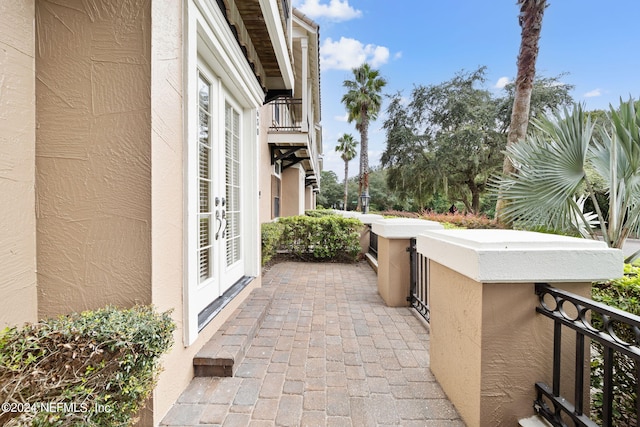 view of patio featuring a balcony and french doors