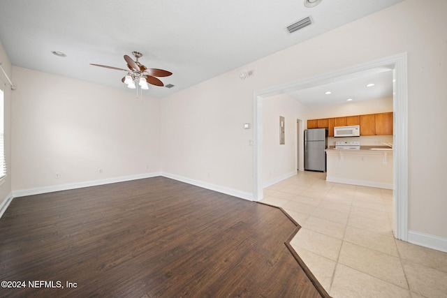 unfurnished living room featuring ceiling fan, light hardwood / wood-style flooring, and sink