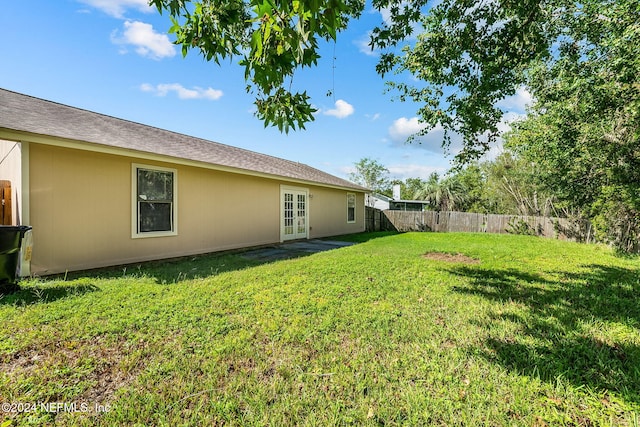view of yard with french doors and a fenced backyard
