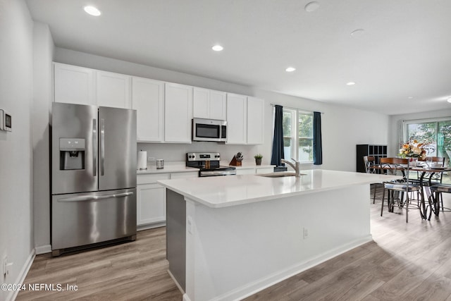 2280 Lincoln Sendero Trl, Jacksonville, FL 32218 - kitchen with white cabinets, an island with sink, sink, appliances with stainless steel finishes, and light hardwood / wood-style floors