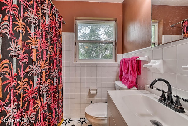 bathroom with tile walls, a shower with curtain, tile patterned floors, vanity, and toilet