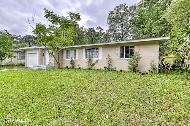 single story home featuring a garage and a front lawn