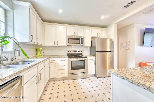 kitchen with appliances with stainless steel finishes, sink, and white cabinetry