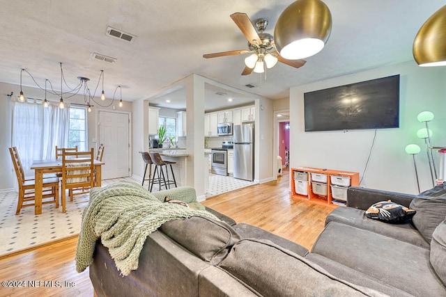 living room featuring ceiling fan and light wood-type flooring