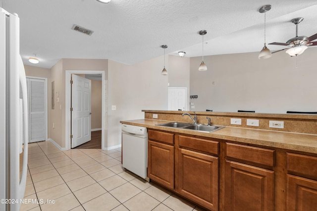 kitchen with hanging light fixtures, light tile patterned flooring, white appliances, ceiling fan, and sink