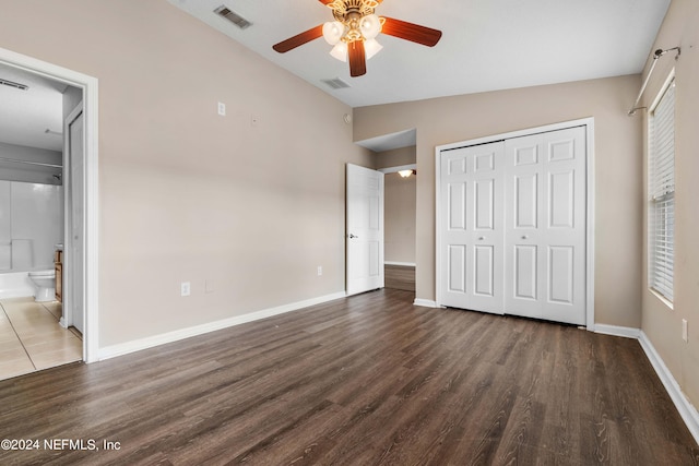 unfurnished bedroom featuring ceiling fan, a closet, ensuite bath, vaulted ceiling, and dark hardwood / wood-style flooring