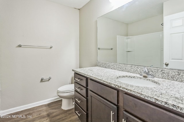 bathroom featuring wood-type flooring, vanity, and toilet