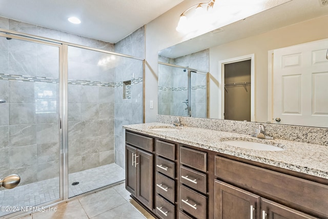 bathroom featuring vanity, tile patterned flooring, and walk in shower