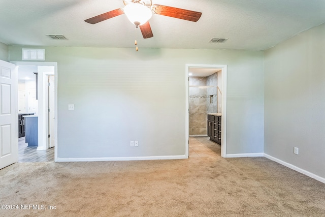 carpeted spare room featuring a textured ceiling and ceiling fan