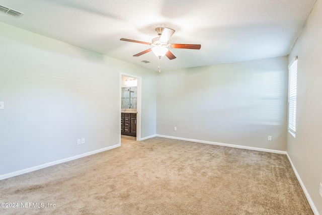 carpeted spare room with ceiling fan and a textured ceiling