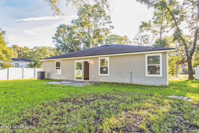 back of house with cooling unit, a lawn, and a patio