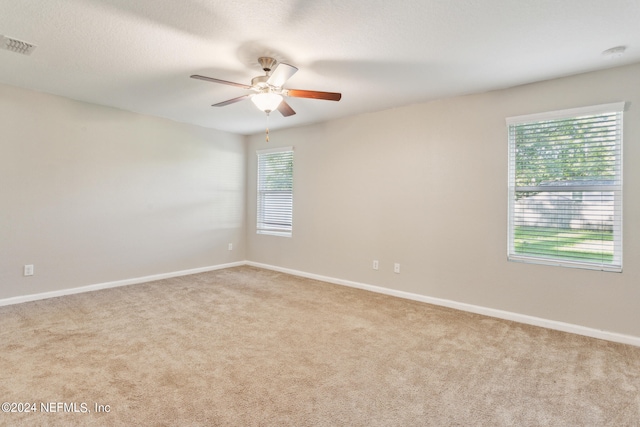 spare room with light colored carpet and ceiling fan