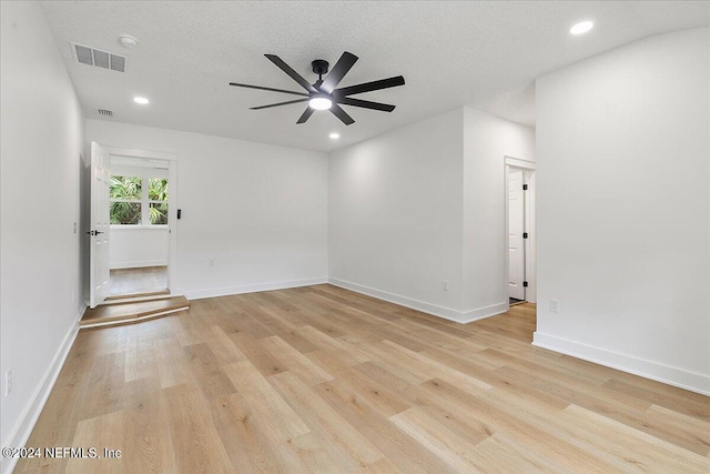 empty room featuring light hardwood / wood-style floors, ceiling fan, and a textured ceiling