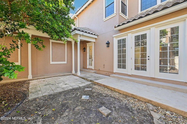 entrance to property featuring french doors and a patio area