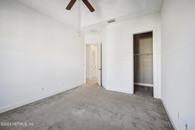 unfurnished bedroom featuring light colored carpet, a closet, and ceiling fan