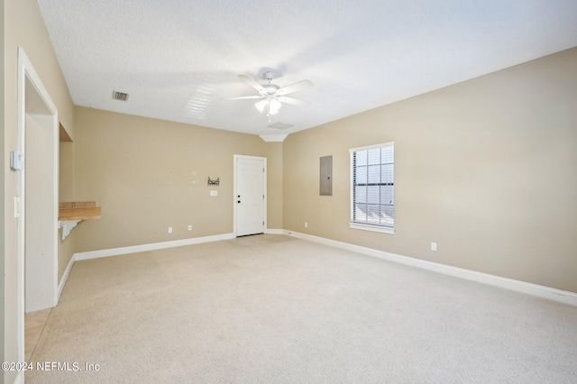 carpeted spare room with ceiling fan, a textured ceiling, and electric panel