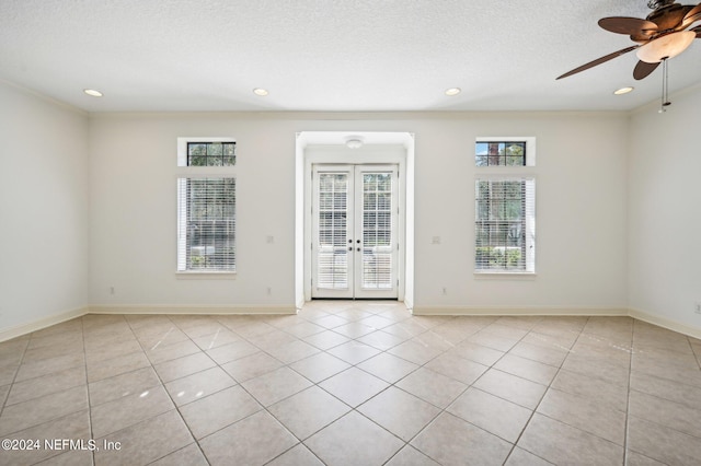 tiled spare room featuring french doors, ceiling fan, a textured ceiling, and plenty of natural light