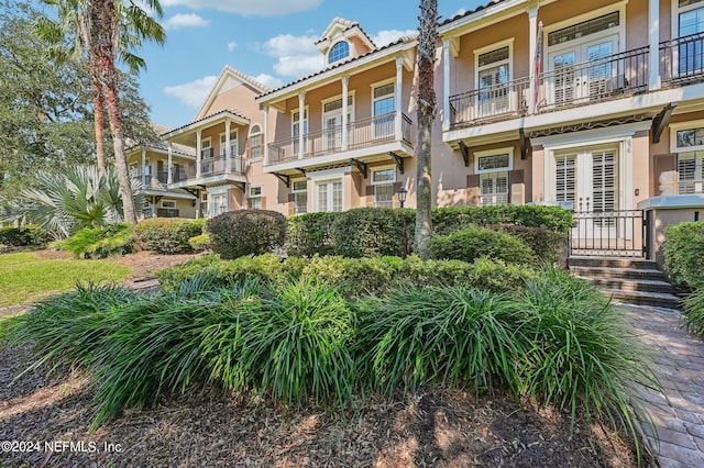 view of front of property featuring french doors and a balcony