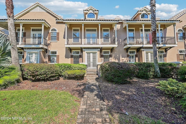 view of front of home with a balcony and french doors