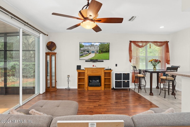 living room with hardwood / wood-style floors, ceiling fan, and a healthy amount of sunlight