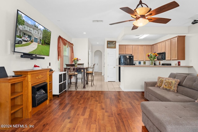 living room featuring light hardwood / wood-style floors and ceiling fan