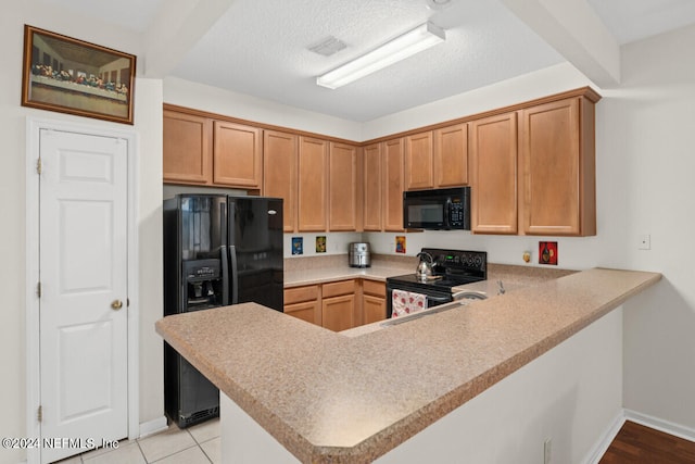 kitchen featuring black appliances, kitchen peninsula, light tile patterned flooring, and a textured ceiling