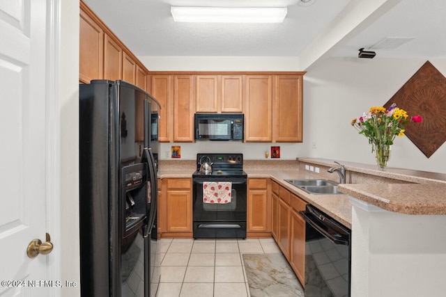 kitchen featuring light stone counters, kitchen peninsula, light tile patterned floors, black appliances, and sink