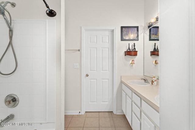 bathroom with tile patterned flooring, a shower, and vanity