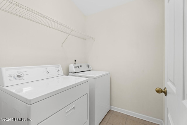 laundry area featuring light tile patterned flooring and separate washer and dryer