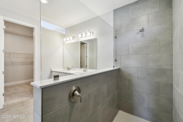 75582 Banyan Way, Yulee, FL 32097 - bathroom with wood finished floors, a tile shower, a spacious closet, and double vanity