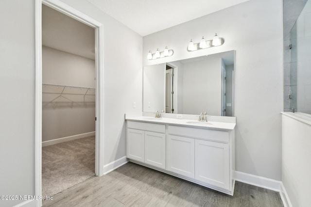 75582 Banyan Way, Yulee, FL 32097 - full bath with double vanity, wood finished floors, a walk in closet, and baseboards