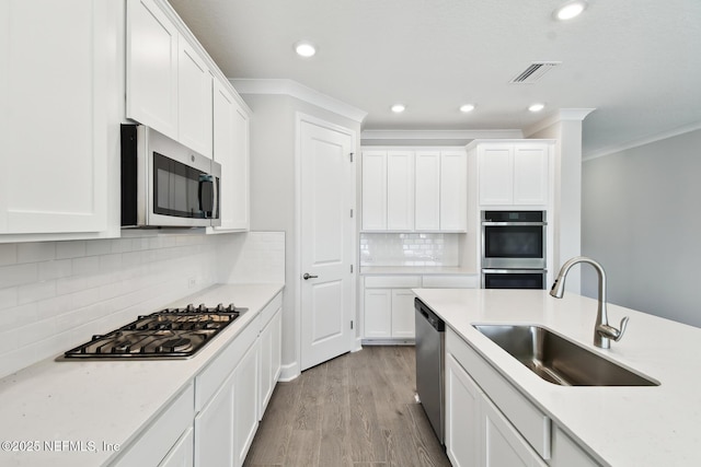 75582 Banyan Way, Yulee, FL 32097 - kitchen featuring stainless steel appliances, a sink, crown molding, white cabinets, and recessed lighting