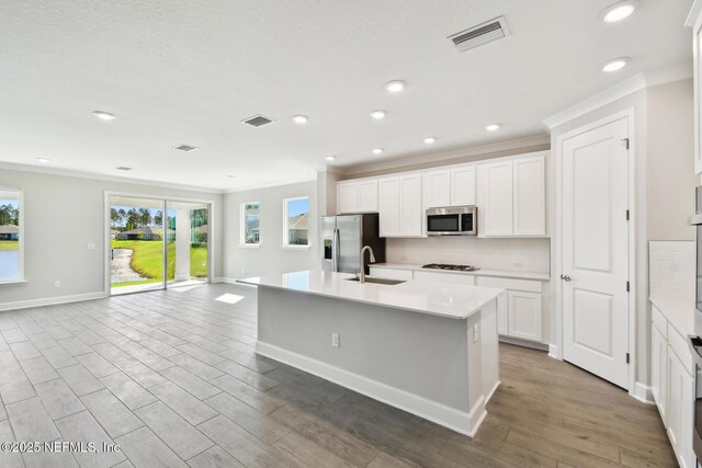 75582 Banyan Way, Yulee, FL 32097 - kitchen with appliances with stainless steel finishes, a sink, crown molding, open floor plan, and a kitchen island with sink