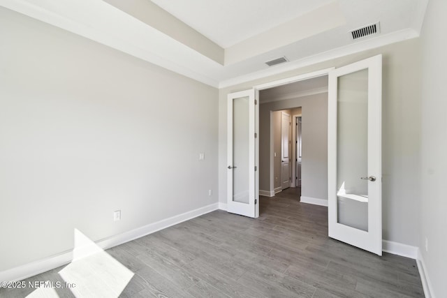 75582 Banyan Way, Yulee, FL 32097 - unfurnished bedroom featuring french doors, wood finished floors, baseboards, a raised ceiling, and ornamental molding